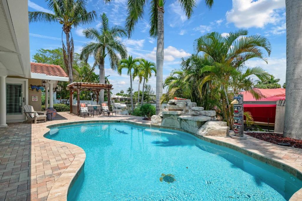 una piscina in un cortile con palme di Waterfront Paradise a Holmes Beach