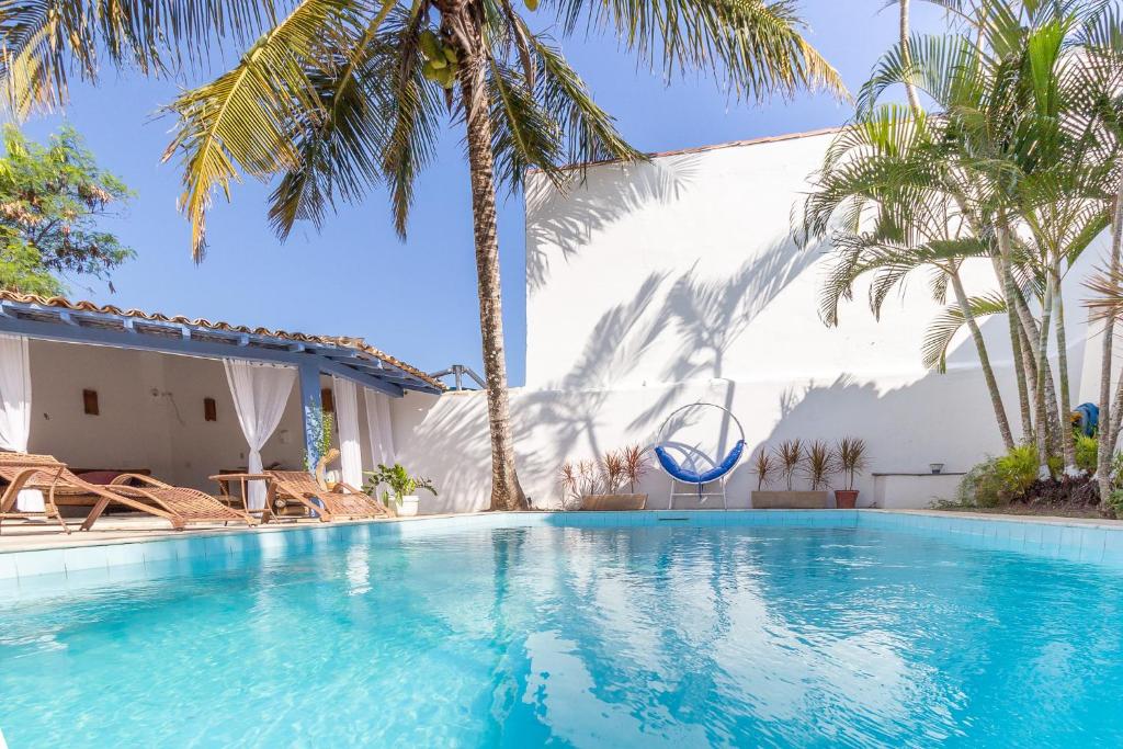 ブジオスにあるPousada Vila Capri - Geribáのヤシの木と建物のあるプール