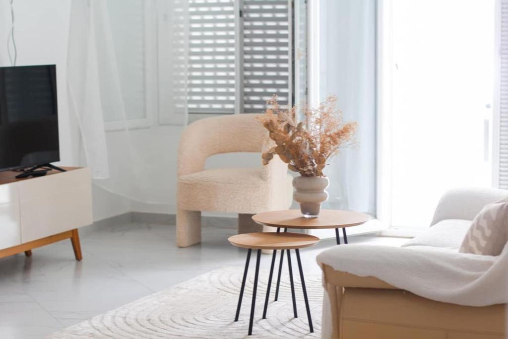 een woonkamer met een stoel en een vaas op een tafel bij Apartment Morabeza in Praia Cidadela in Praia