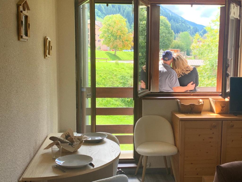 a couple looking out of a window with a view at Le cocon dans les nuages in La Celle-sous-Gouzon