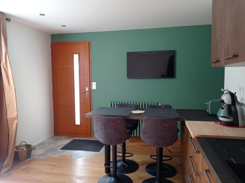 een keuken met een tafel met stoelen en een televisie bij Appart avec Jardin & Vue Montagne - Proche Ski Briançon Serre Che in Villar-Saint-Pancrace