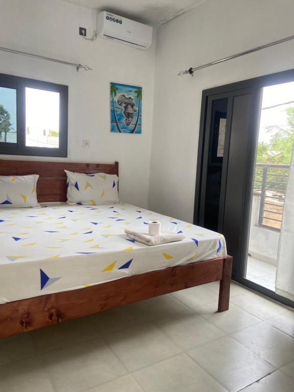 a bedroom with a large bed with blue and yellow sheets at Le Poulagou in Saint-Louis