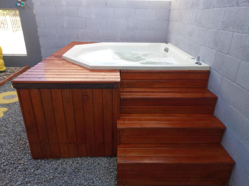 a bath tub sitting on top of wooden steps in a bathroom at Casa de férias 2 quartos in Penha