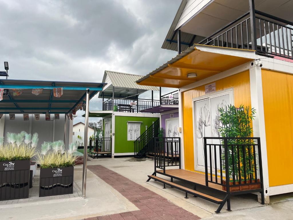 a row of houses with yellow and green at Caca Kabin in Mersing
