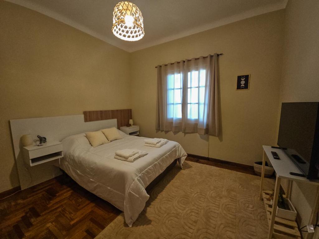 a bedroom with a bed and a window and a television at PH familiar en La Perla ideal para relax y turismo in Mar del Plata