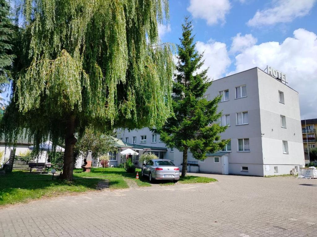 a car parked in front of a white building at Apart Iwona 209-210 in Koszalin
