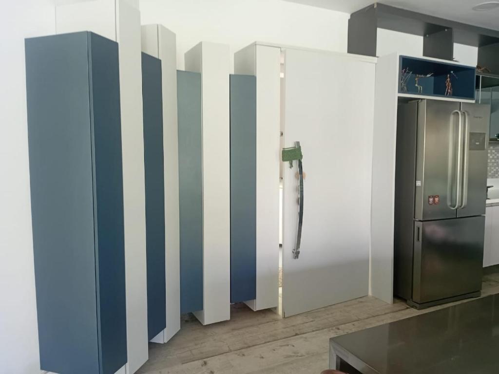 マラゴージにあるCasa jardinsの冷蔵庫とストライプの壁があるキッチン