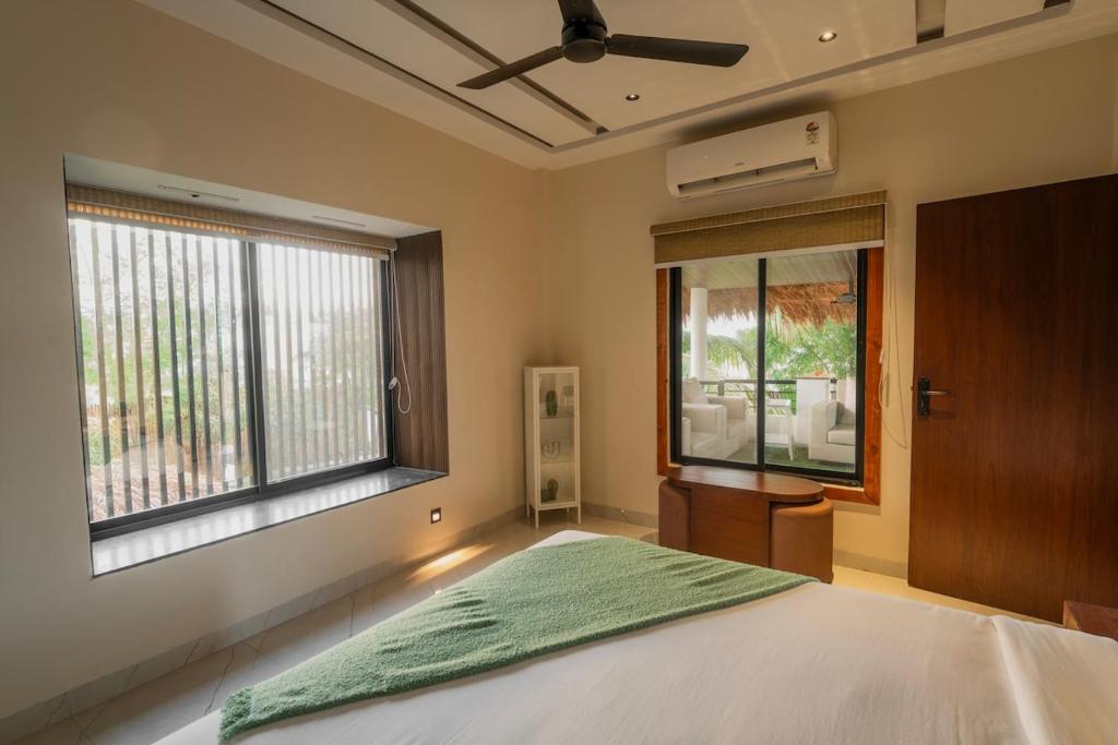 Lush Life - Private Bali-Inspired Villa في Kanāria: غرفة نوم بسرير ونوافذ كبيرة