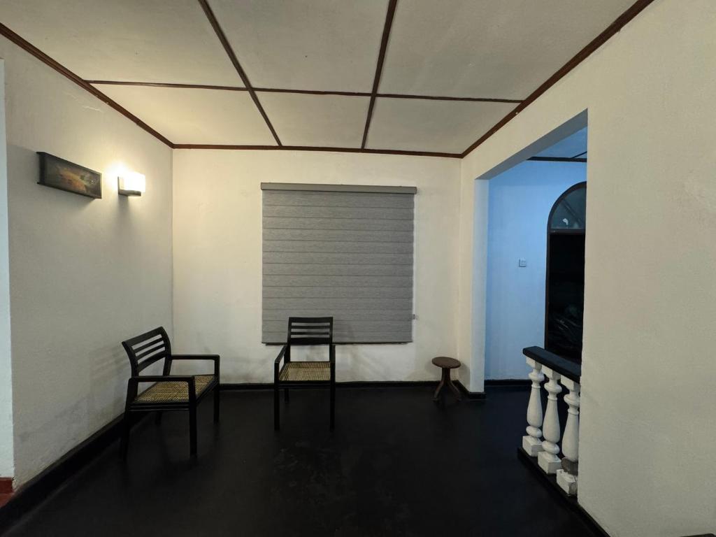 two chairs and a table in a room with a window at Seliya Villa Retreat in Balapitiya