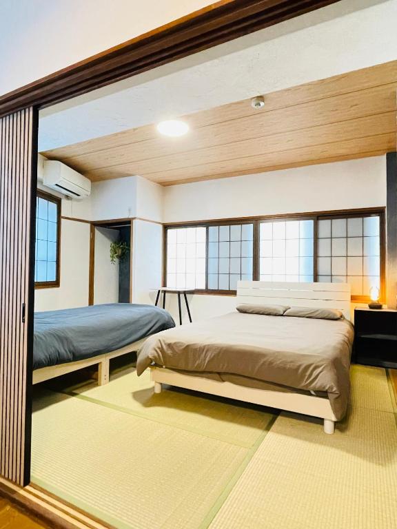 two beds in a bedroom with a mirror at Stay Narimasu - 3rooms Apartment, 4min to Narimasu station, 1min to Donki in Tokyo