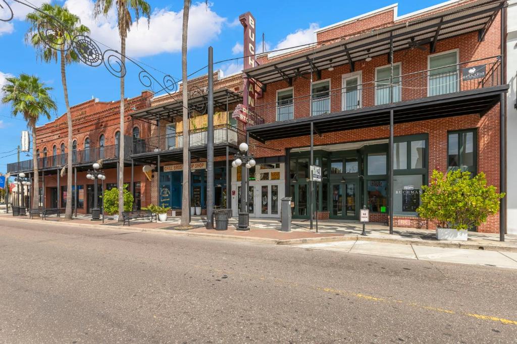 タンパにあるCasa Ybor Apartments on 7th Aveの椰子の木が並ぶ通りの赤レンガ造り