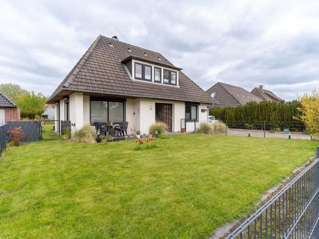 a house with a green lawn in front of it at Ferienwohnung Küstenluft in Tating in Tating