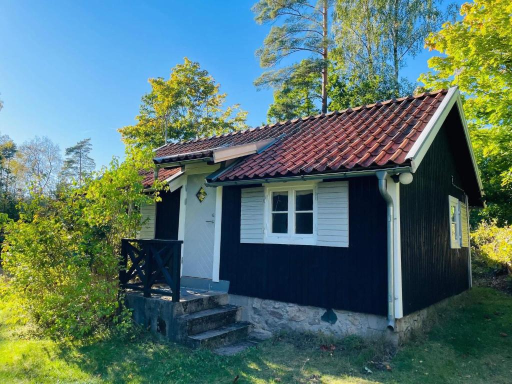 a small black and white house with a red roof at 4 person holiday home in HALLABRO-By Traum in Svarvaremåla