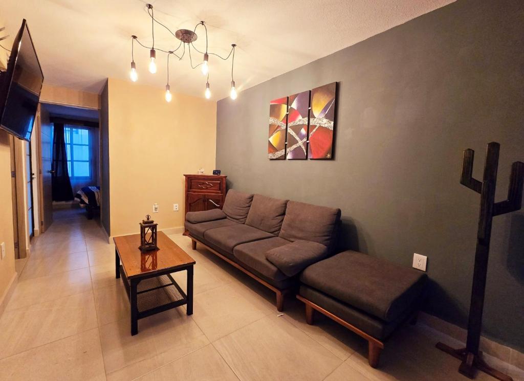 een woonkamer met een bank en een tafel bij Casa Fray in San Miguel de Allende