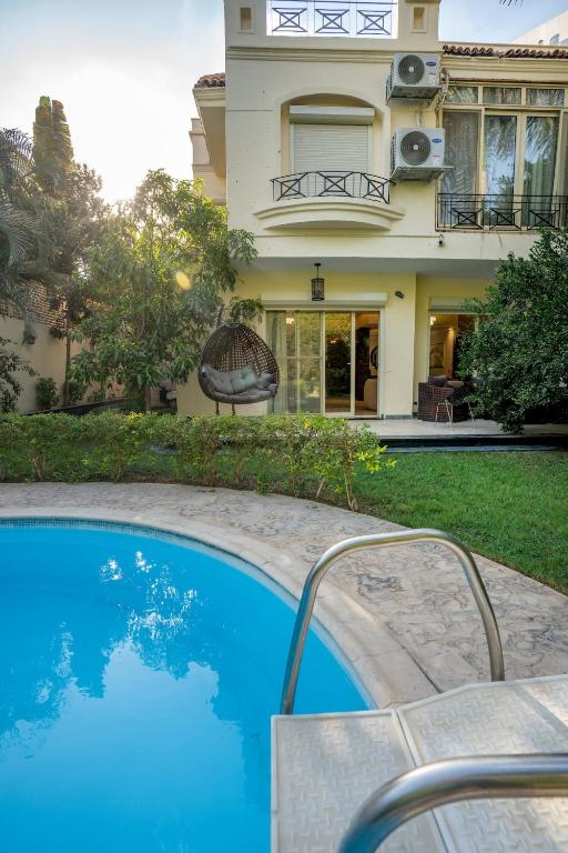 a house with a swimming pool in front of a house at Luxury Family Villa with Private Pool in Sheikh Zayed Khan in 6th Of October