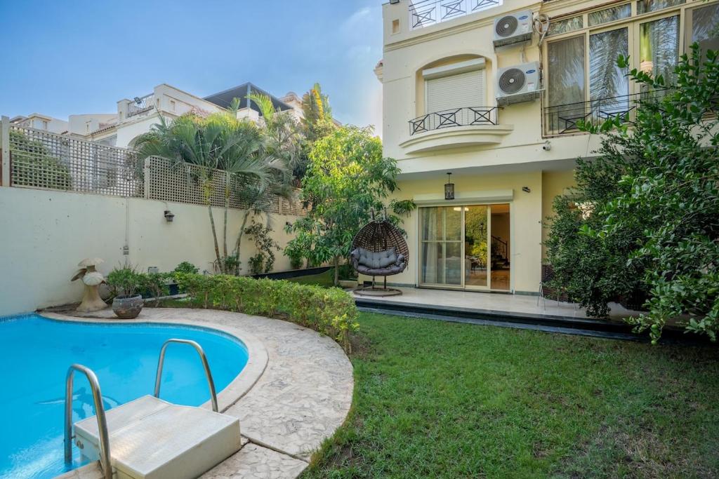 a house with a swimming pool in the yard at Villa Zayed Khan in 6th Of October