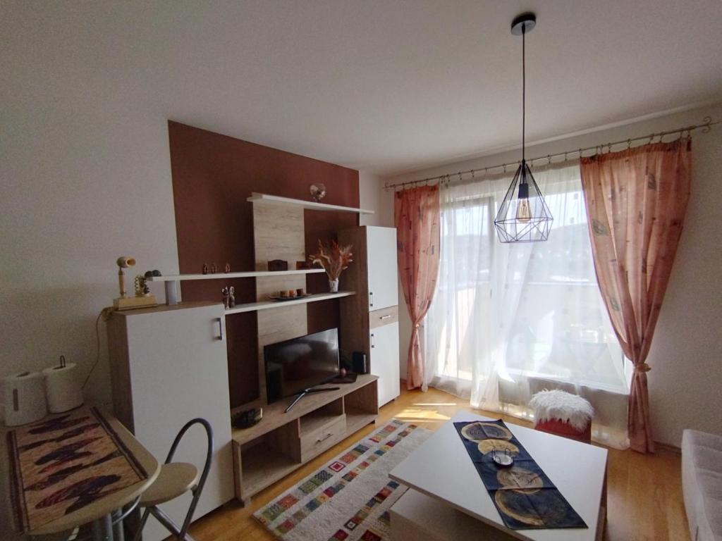 a living room with a table and a window at Studio - Bee Happy in Sarajevo