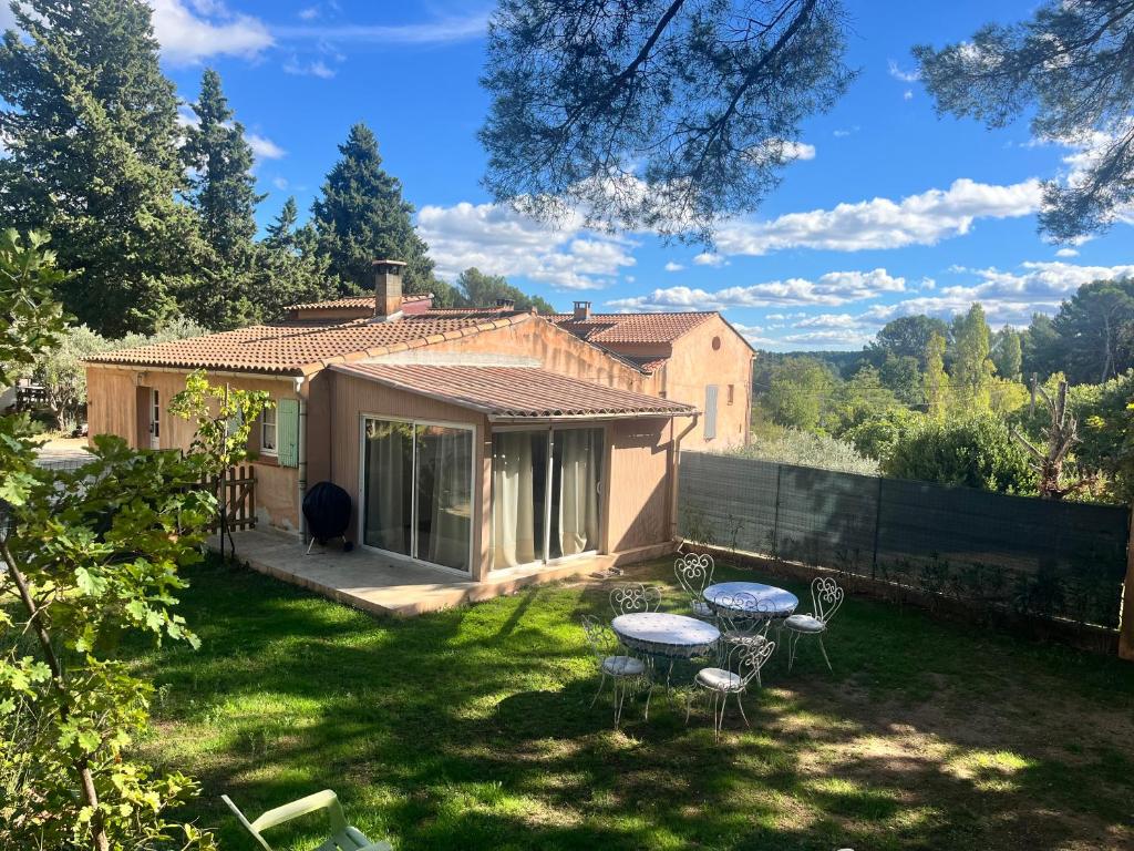 una casa con tavolo e sedie nel cortile di Aix-en-Provence, Maison provençale au calme de la campagne avec Jacuzzi ad Aix en Provence