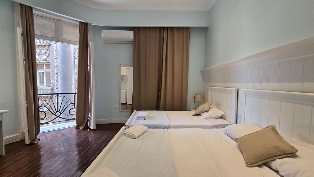 a bedroom with two beds and a large window at Cairo Orginals Hostel in Cairo