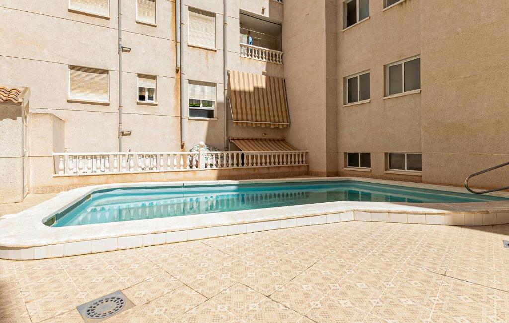 a swimming pool in front of a building at Awesome Apartment In Torrevieja With Wifi in Torrevieja