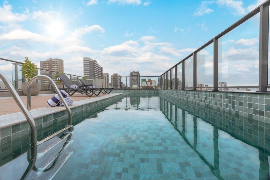 a swimming pool on the roof of a building at Cozzy Premium Paulista Hotel in Sao Paulo