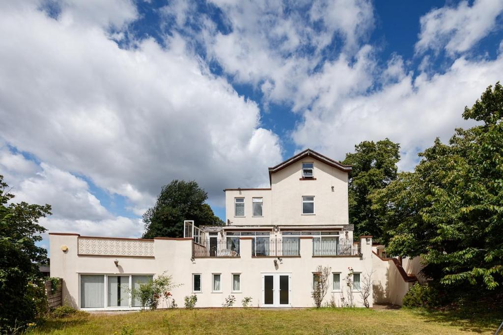 a large white house on a hill with trees at Beautiful 'Mayfield' Villa with private pool! in Manchester