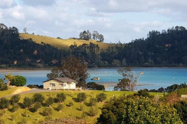 a house on a hill next to a lake at The Cottage on the Olive Grove in Russell