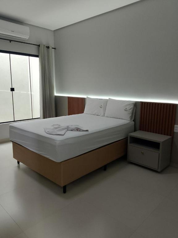 Colinas do TocantinsにあるRosmarry Hotelのベッドと窓のある寝室