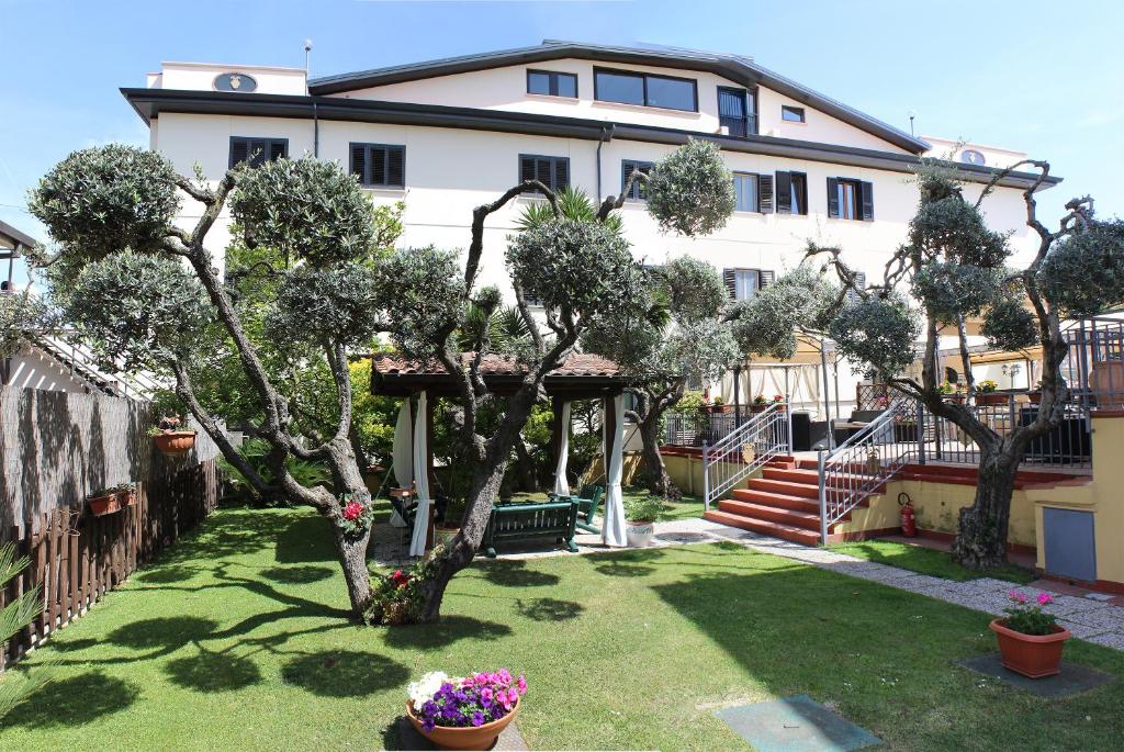 ein Haus mit einem Garten mit Bäumen und Blumen in der Unterkunft Hotel Nespolo D'Oro in Lariano