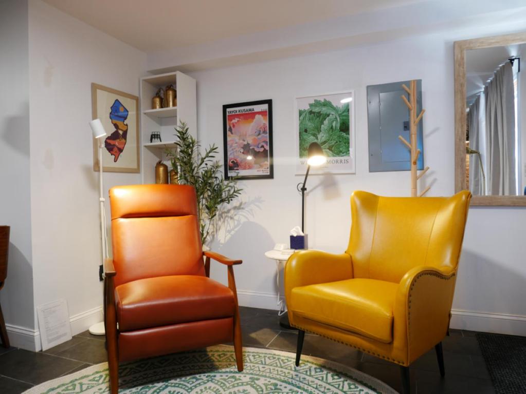two yellow chairs in a living room with a rug at 10 Minute walk to Light Rail in Jersey City