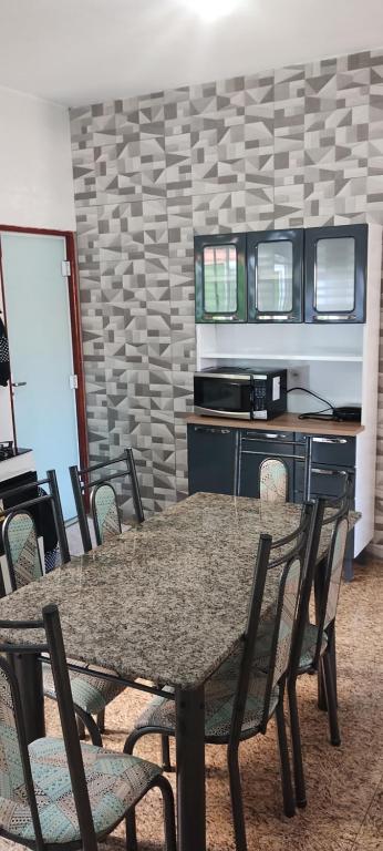 une salle à manger avec une table et des chaises dans l'établissement Kitnet montanha mágica, à São Thomé das Letras