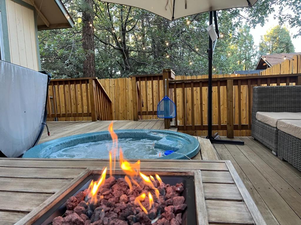 a hot tub with a fire pit in a backyard at Sugar Suites Cozy Cabin Retreat Near Big Bear in Sugarloaf