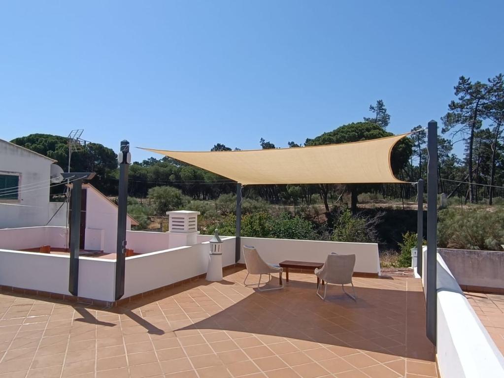 un patio con tavolo e ombrellone abbronzanti di Casa do Poço a Vila Real de Santo António