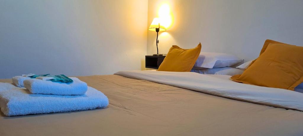 a bedroom with two beds with blue and yellow pillows at Ybarra Chaltén Cabins in El Chalten