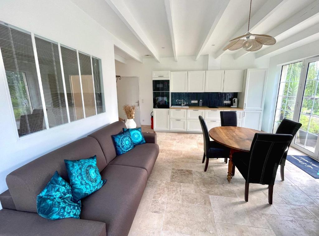 a living room with a couch and a table at Domaine des Anes - Gite des Mûriers 