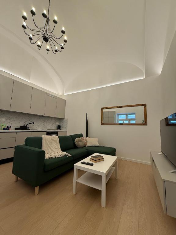 a living room with a green couch and a table at Luxury apartment in the historic city center in Košice