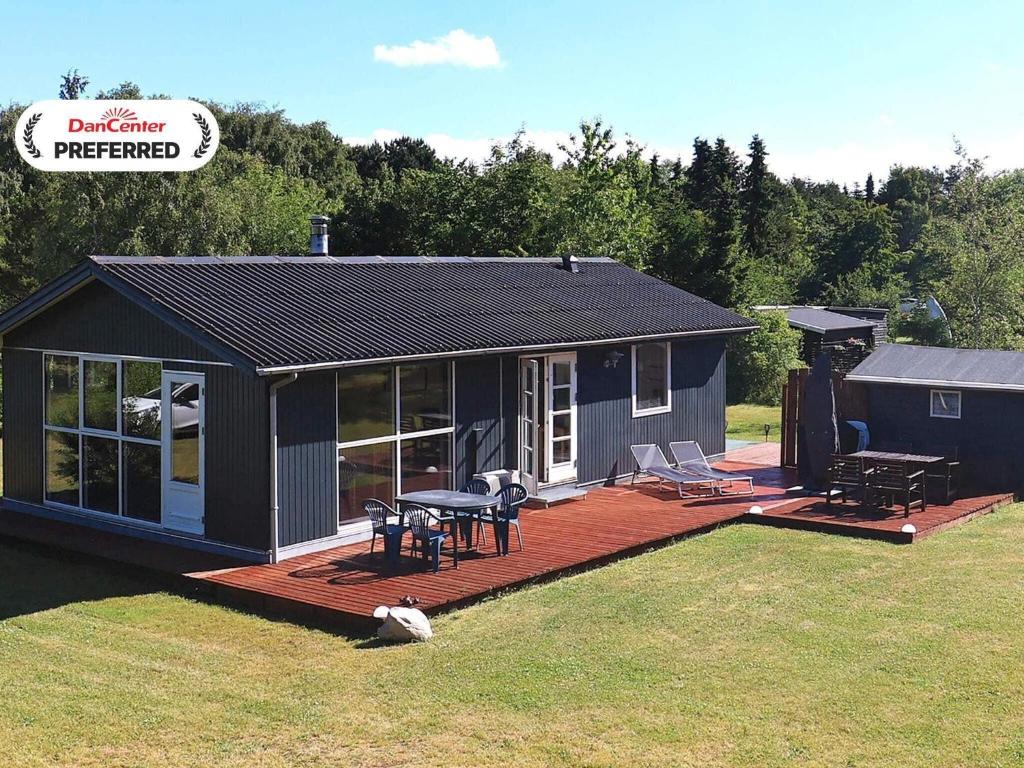 a small house with a deck and a patio at 6 person holiday home in Nibe-By Traum in Nibe