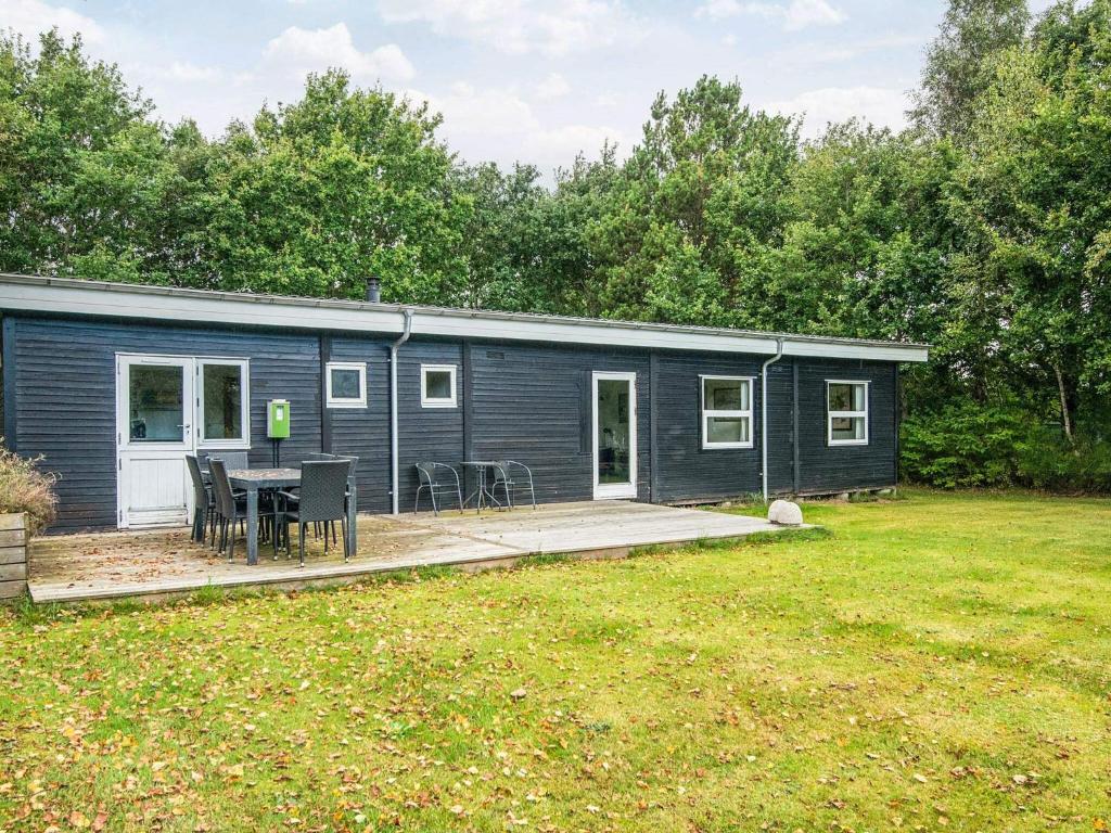 a blue modular house with a patio and a yard at 6 person holiday home in Ørsted-By Traum in Ørsted