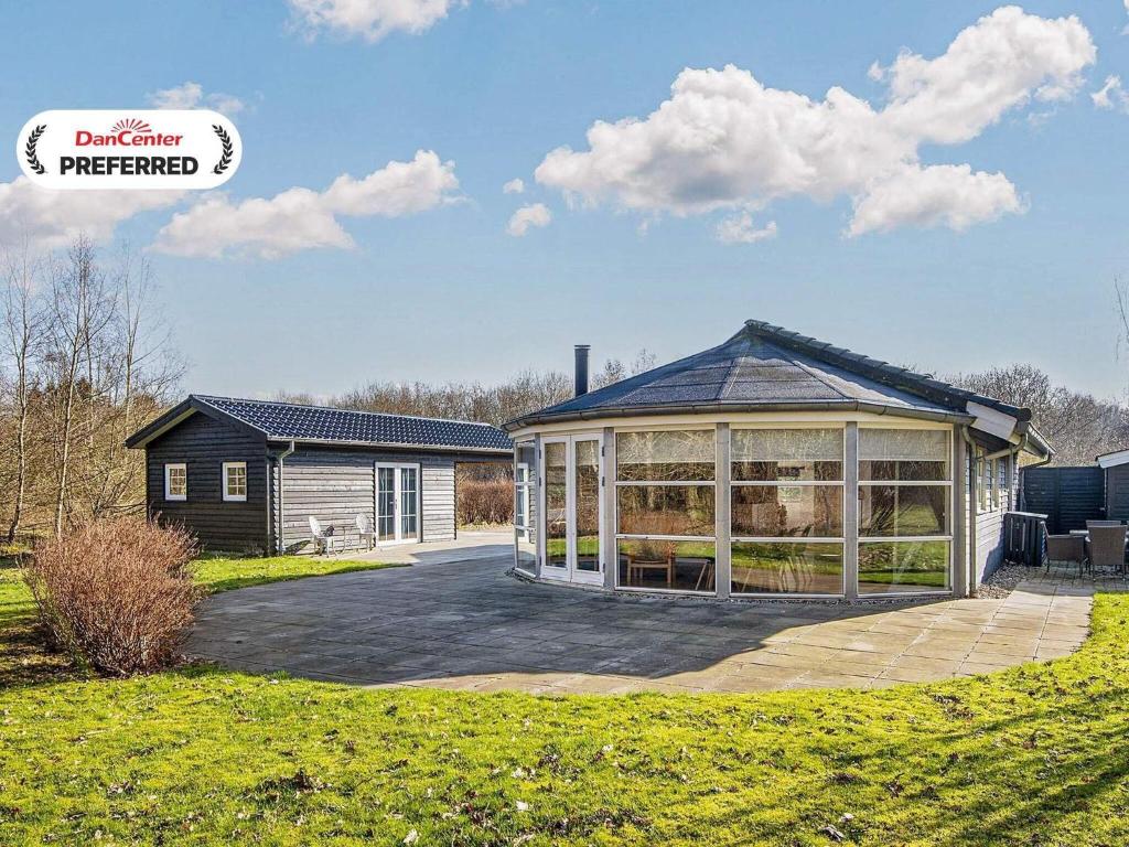 a house with a large conservatory in a yard at 4 star holiday home in Ansager-By Traum in Ansager