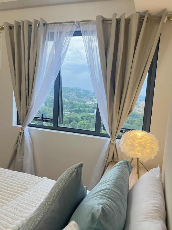 a bedroom with a bed and a large window at ARA Condotel in Cebu City