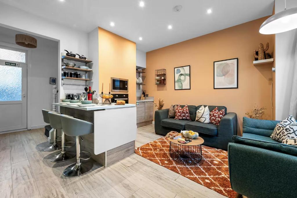 a kitchen and living room with a couch and a table at Aylesbury House 3 En-suite Bedrooms Parking Pets in Portsmouth