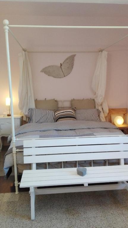 sypialnia z białym łóżkiem z baldachimem w obiekcie Sweet Home w mieście Faggeto Lario 