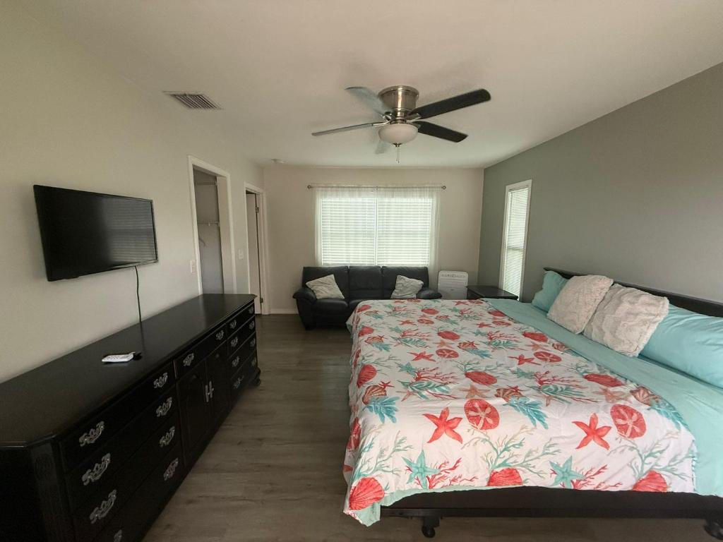 Un dormitorio con una cama y un televisor de pantalla plana. en Sarasota suites, en Sarasota
