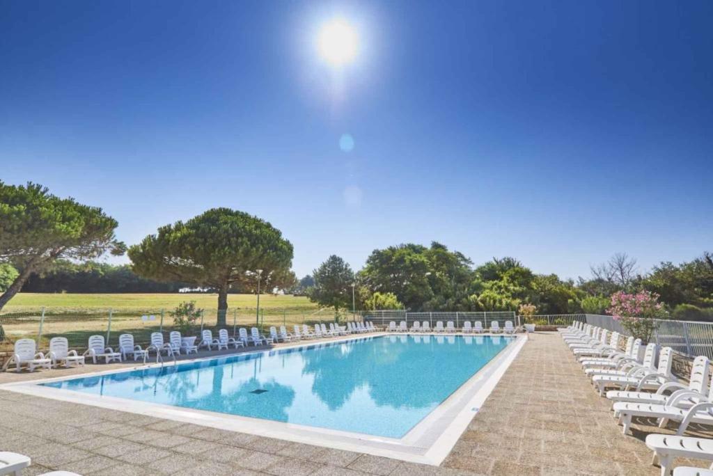 a swimming pool with chairs and a bunch ofitures at Apartments in Savudrija - Istrien 11954 in Bašanija
