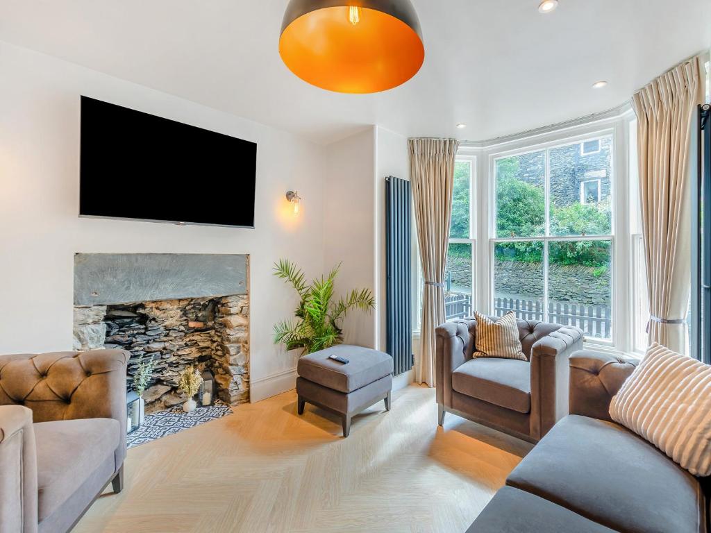 a living room with a couch and a fireplace at Slate House in Bowness-on-Windermere