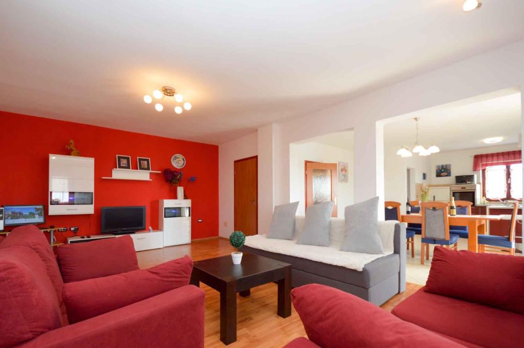 a living room with red walls and a white couch at Apartment in Sajini - Istrien 35275 in Šajini