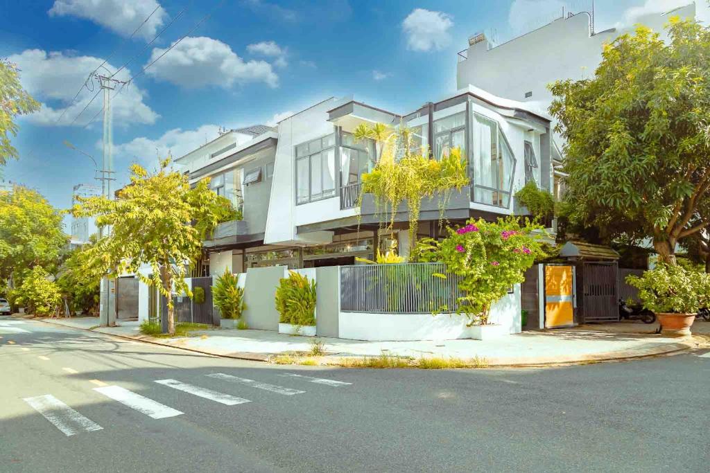 a white house with trees on the side of the street at Mykhe Beach 10 minutes Free pick-up Breakfast service BBQ Private pool villa in Da Nang