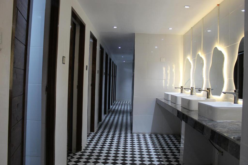 a bathroom with a row of sinks and mirrors at Isa- Hostel in Panglao