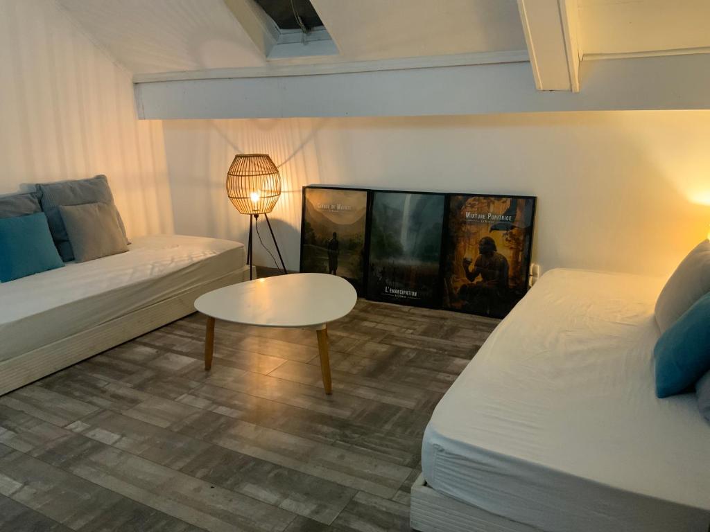 ein Wohnzimmer mit Sofa und Tisch in der Unterkunft Maison Bleu-Oxygène in Saint-Joseph