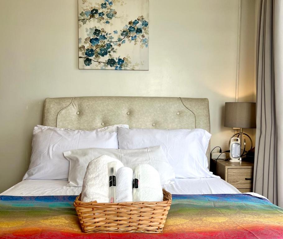 a bedroom with a basket of towels on a bed at Elles Escape - One Bedroom with Balcony in Bacolod